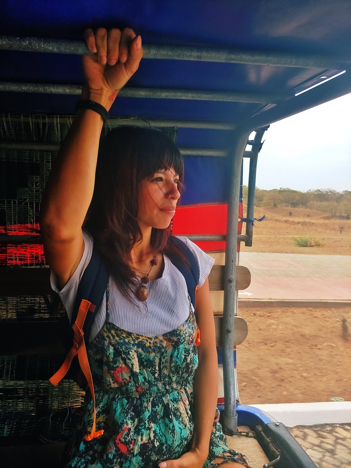 Turista sentada en la parte trasera de una Hilux en movimiento, usando este transporte local entre pueblos en Santiago, Cabo Verde.