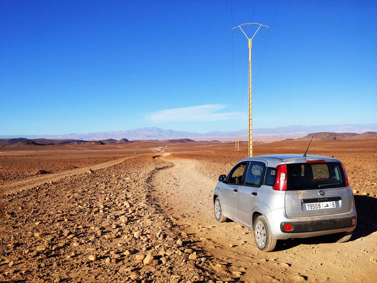 Voiture sur la route désertique entre Merzouga et Zagora, Maroc