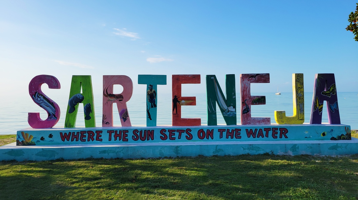 Grandes lettres colorées "Sarteneja" avec vue sur la mer des Caraïbes